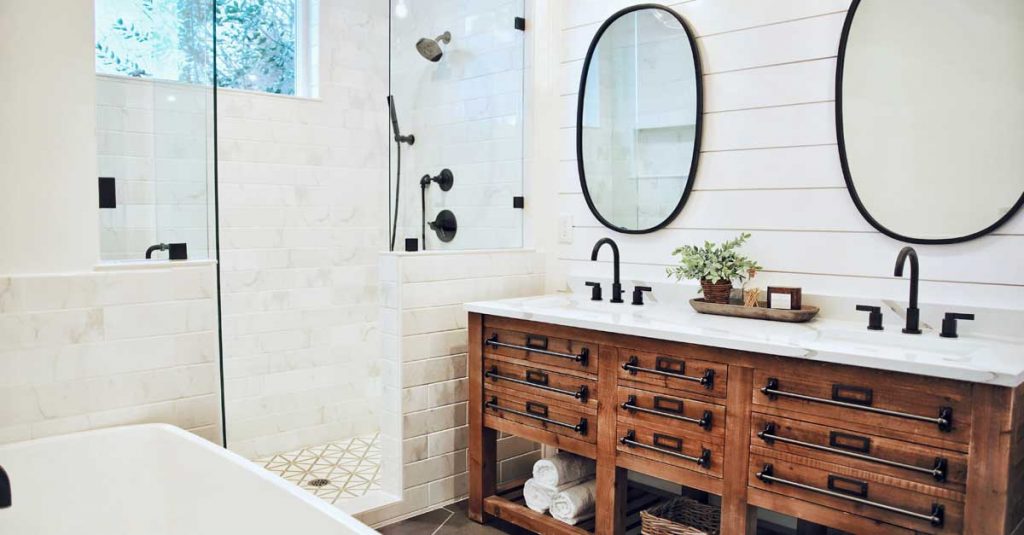 Photo of a bathroom with a rustic wood vanity with double sink, two mirrors, and a white tiled shower area with black low flow shower head