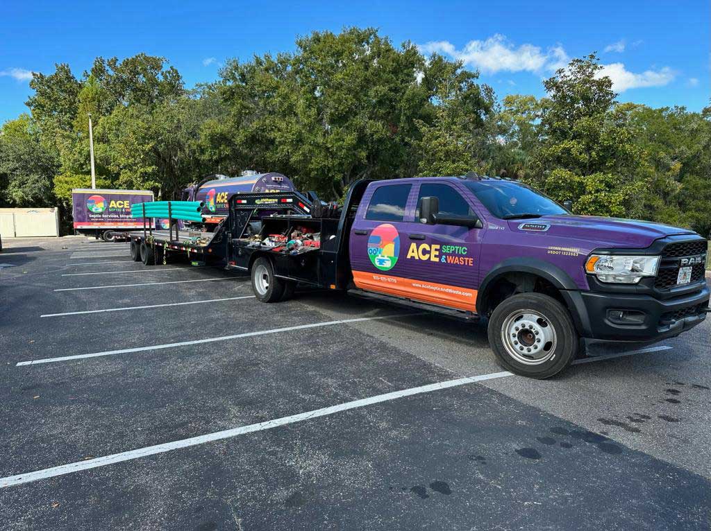 ACE Septic-branded vehicles and trailers in a parking lot.
