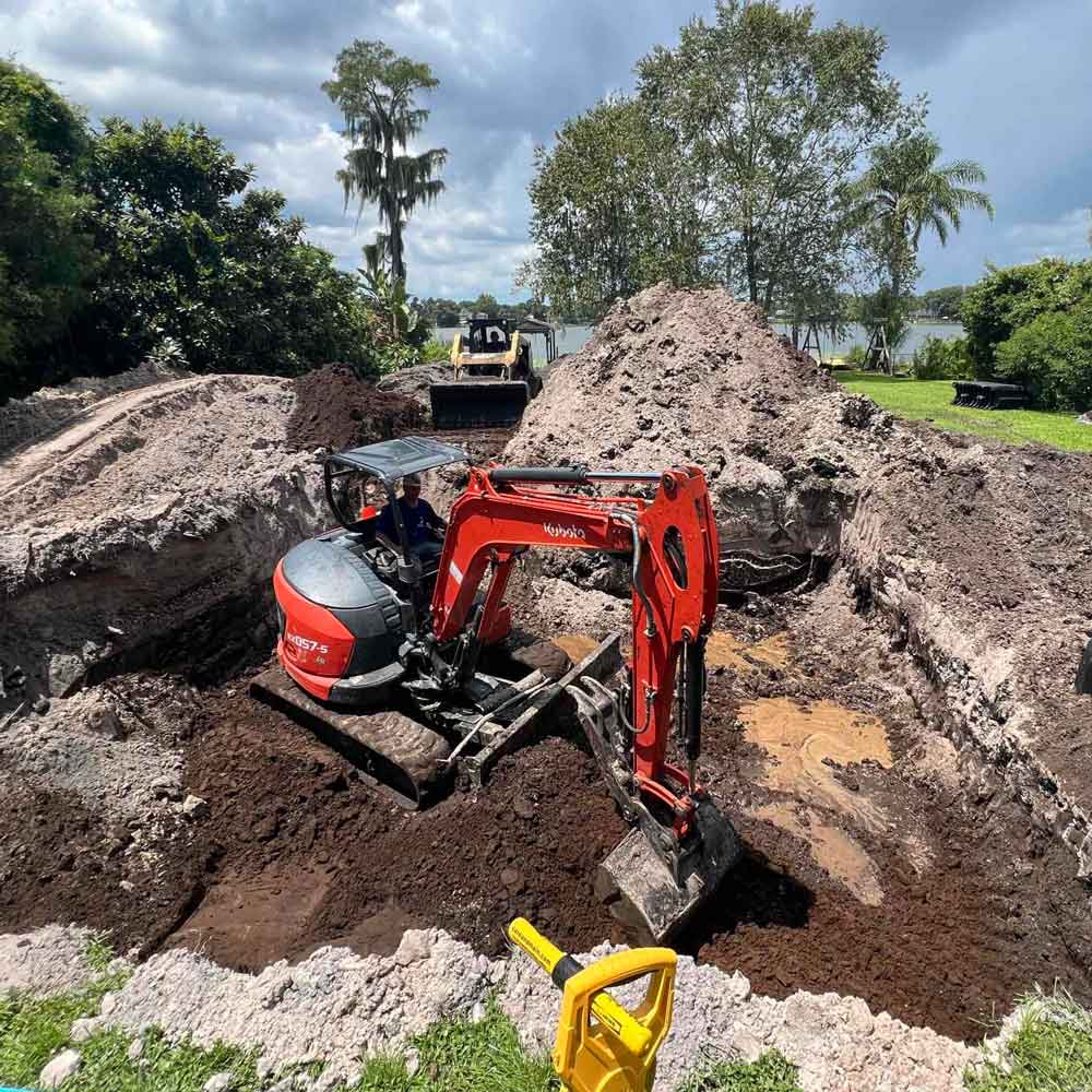 A backhoe and bulldozer clearing ground for a septic system drain field.