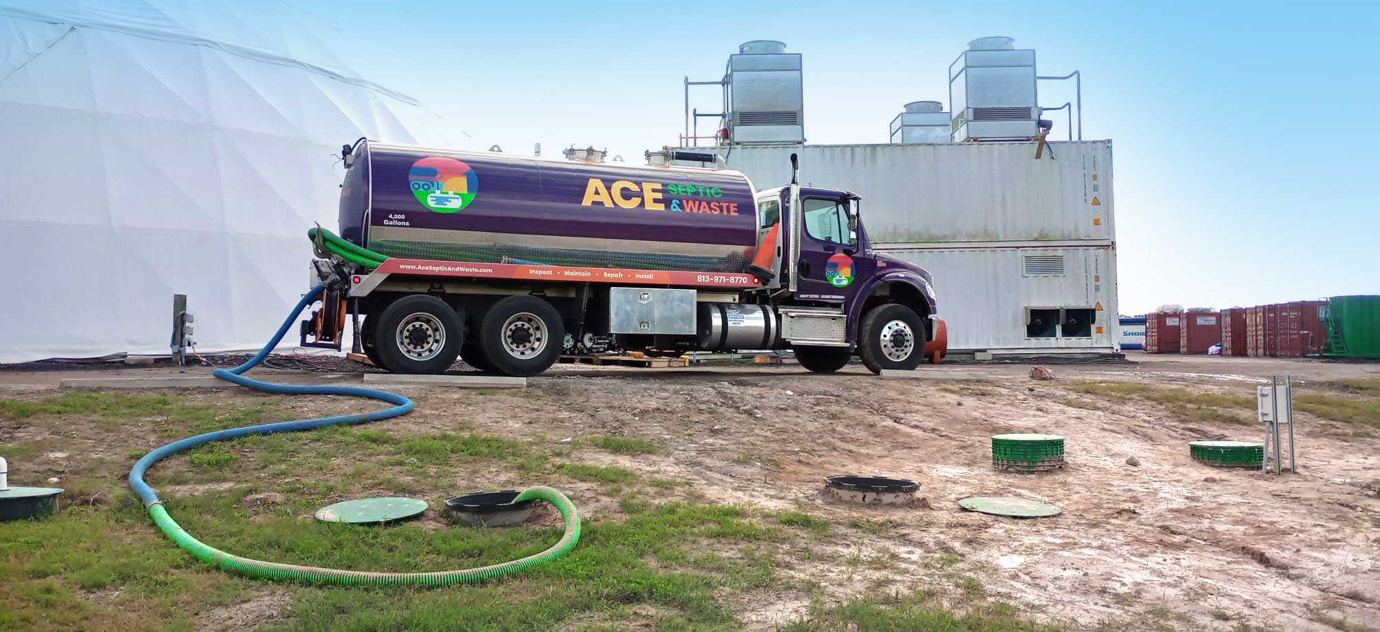 Septic truck pumping out wastewater from an underground septic tank at a business complex.