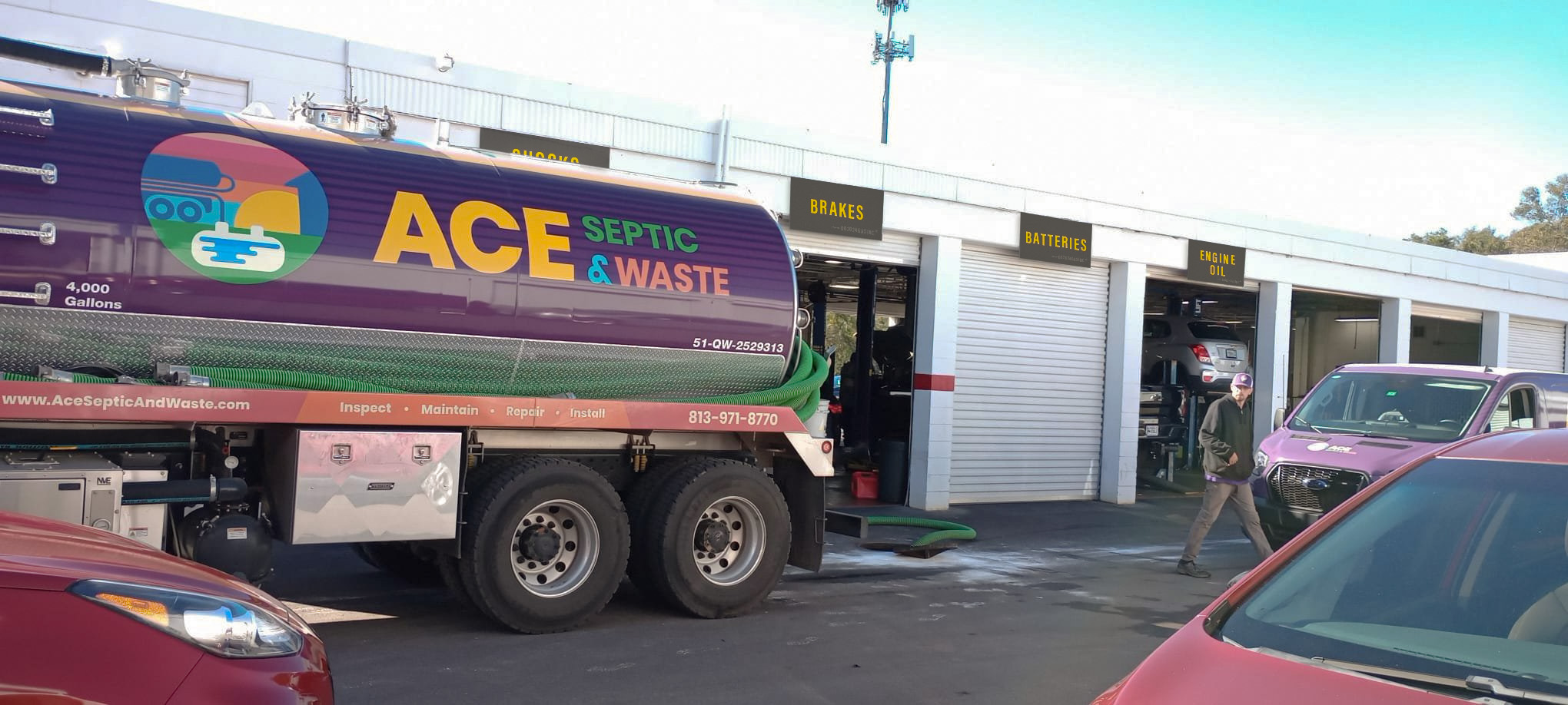 A septic truck with the ACE Septic & Waste logo servicing a mechanic shop.