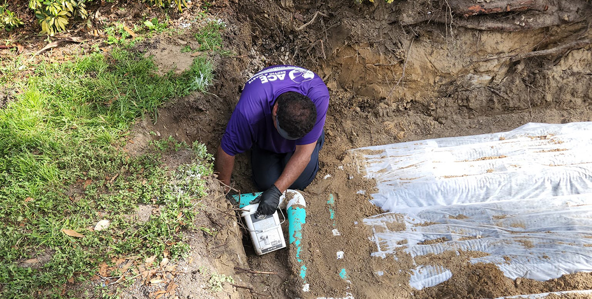 A man connecting a drain field to an underground pipeline.