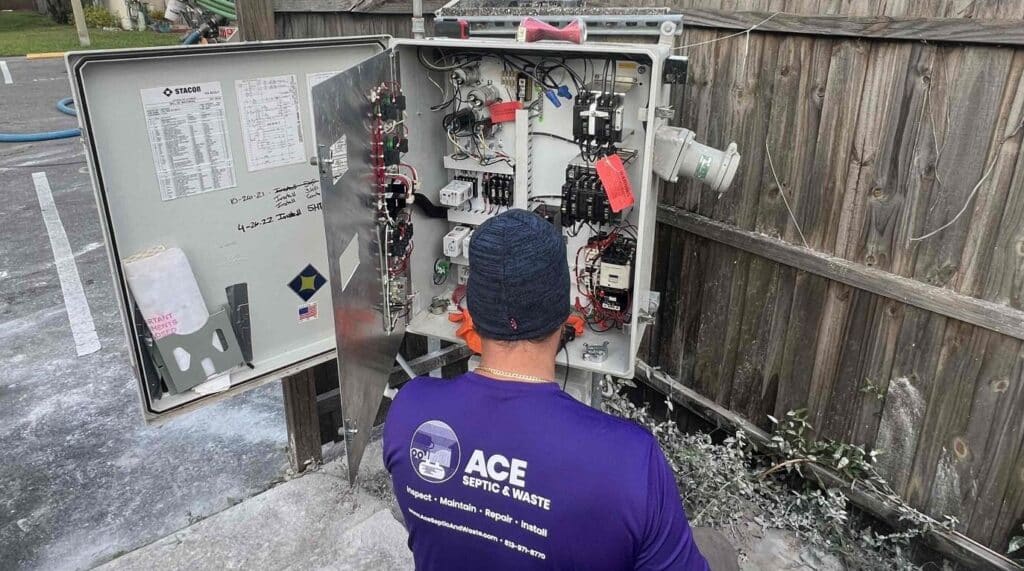 A worker inspecting the control panel of a lift station.