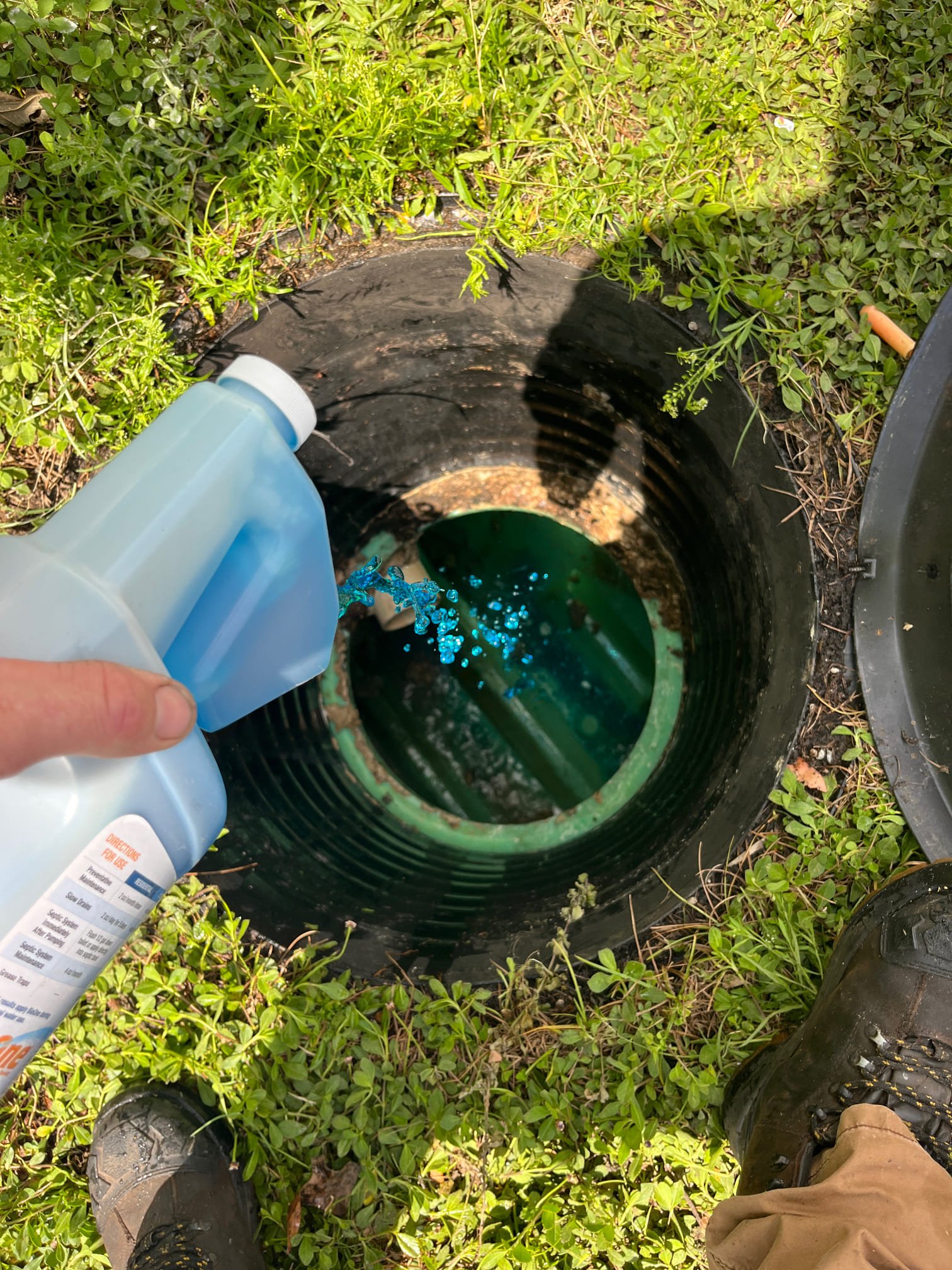 A newly-pumped septic tank with a cleaning solution being added .