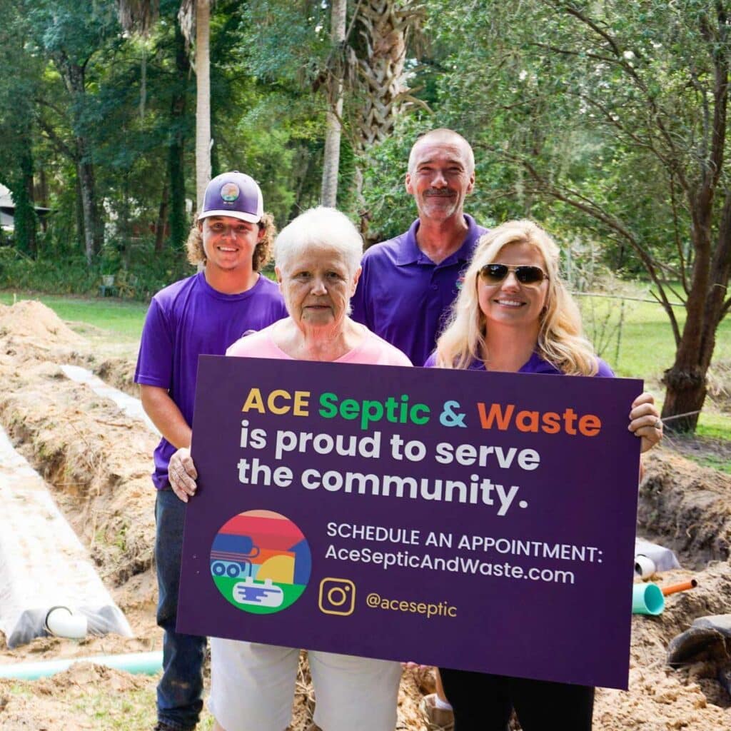 Group photo of ACE employees and their client, holding a sign