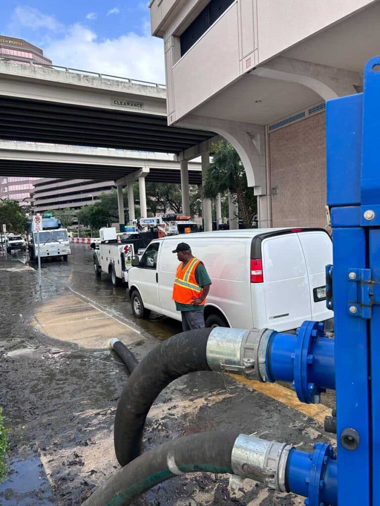 A city worker clearing storm drains after Hurricane Helene.